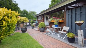 A patio area with outdoor seating, potted plants, and a wooden fence.