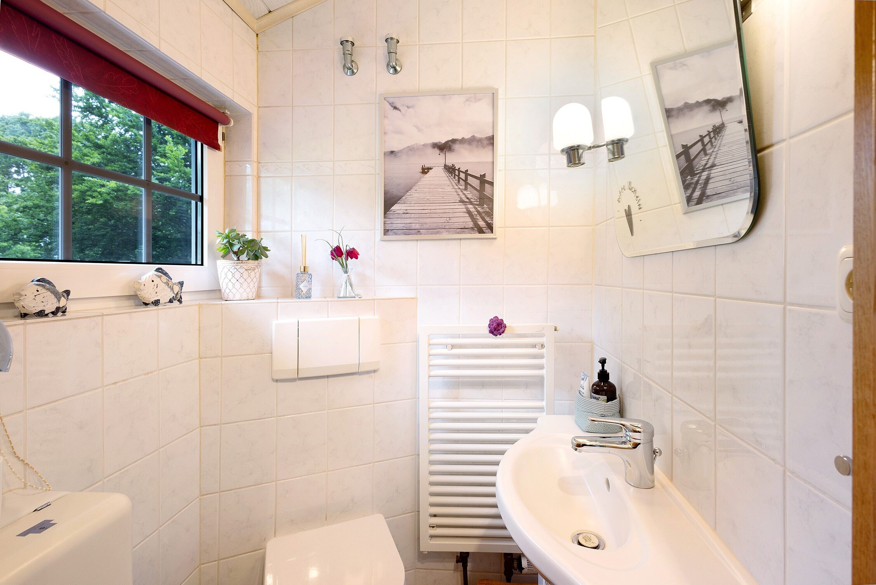 Un baño con inodoro, lavabo y ventana.