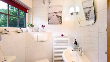 Un baño con inodoro, lavabo y ventana.