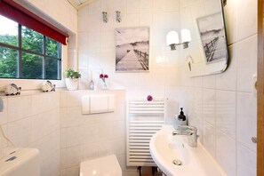Un baño con inodoro, lavabo y ventana.