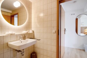 Une salle de bain moderne avec un lavabo, un miroir et des toilettes.