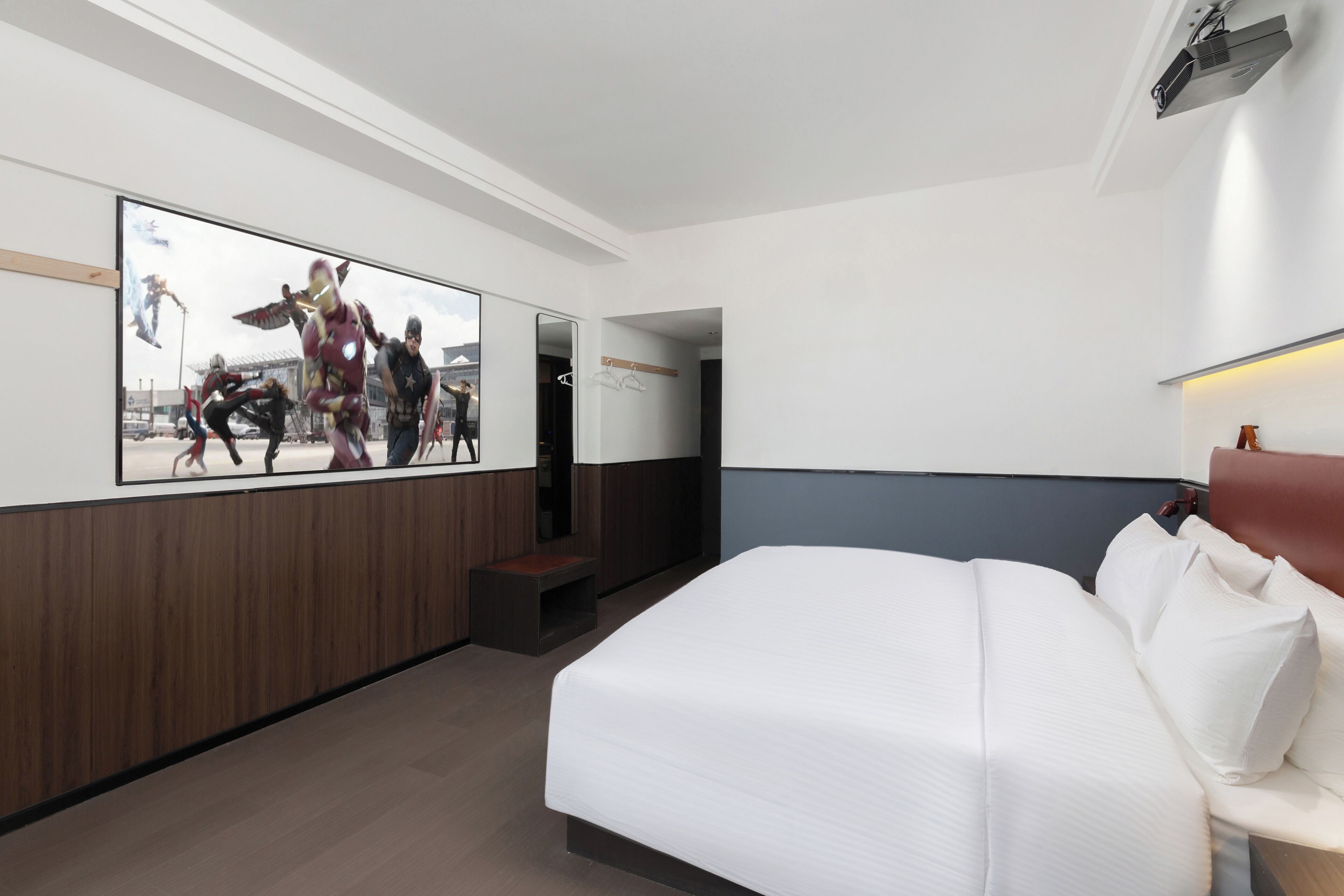 Ein Hotelzimmer mit einem großen Bett, einem flachbildfernseher an der Wand, einer Holzpaneelverkleidung und einer kleinen Sitzecke.