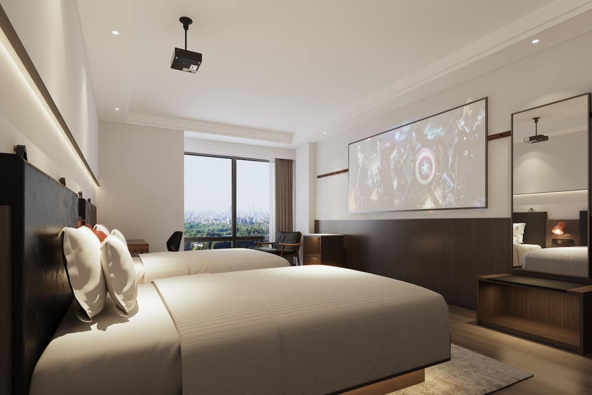 A modern hotel room with a large bed, a city view, a projector screen, and a large mirror.