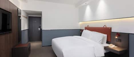Una habitación de hotel moderna con una cama grande, mesitas de noche, un televisor y un armario.