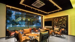 A modern interior with leather chairs, tables, and a large window offering a city view. - Mcsrh Hotel -Chengdu Jiuyanqiao (Chengdu)