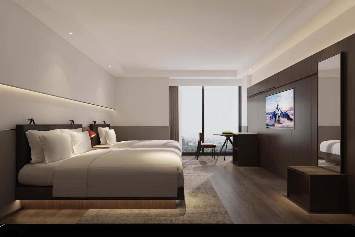 A modern hotel room with a large bed, a TV, and a city view.