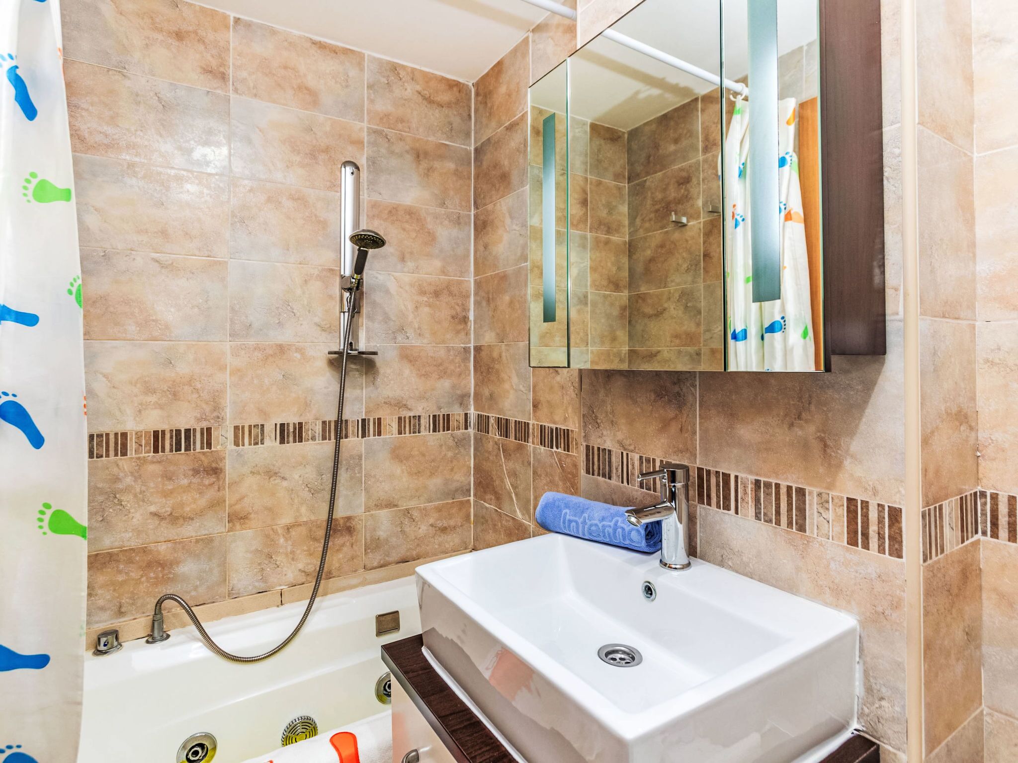 Een badkamer met een bad, wastafel en douche.