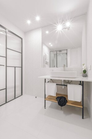 A modern bathroom with a white sink, mirror, and a towel rack. - Ototo Luxury Living (Thessaloniki)