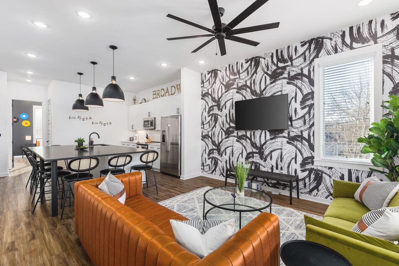 A modern living room with a sofa, a coffee table, and a TV mounted on the wall.