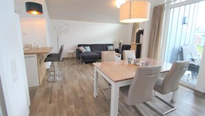 A modern living room with a sofa, coffee table, and dining area.