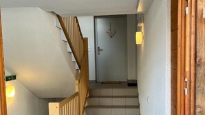 Un escalier avec des rampes en bois menant à une porte ornée d’un motif en forme de cœur.