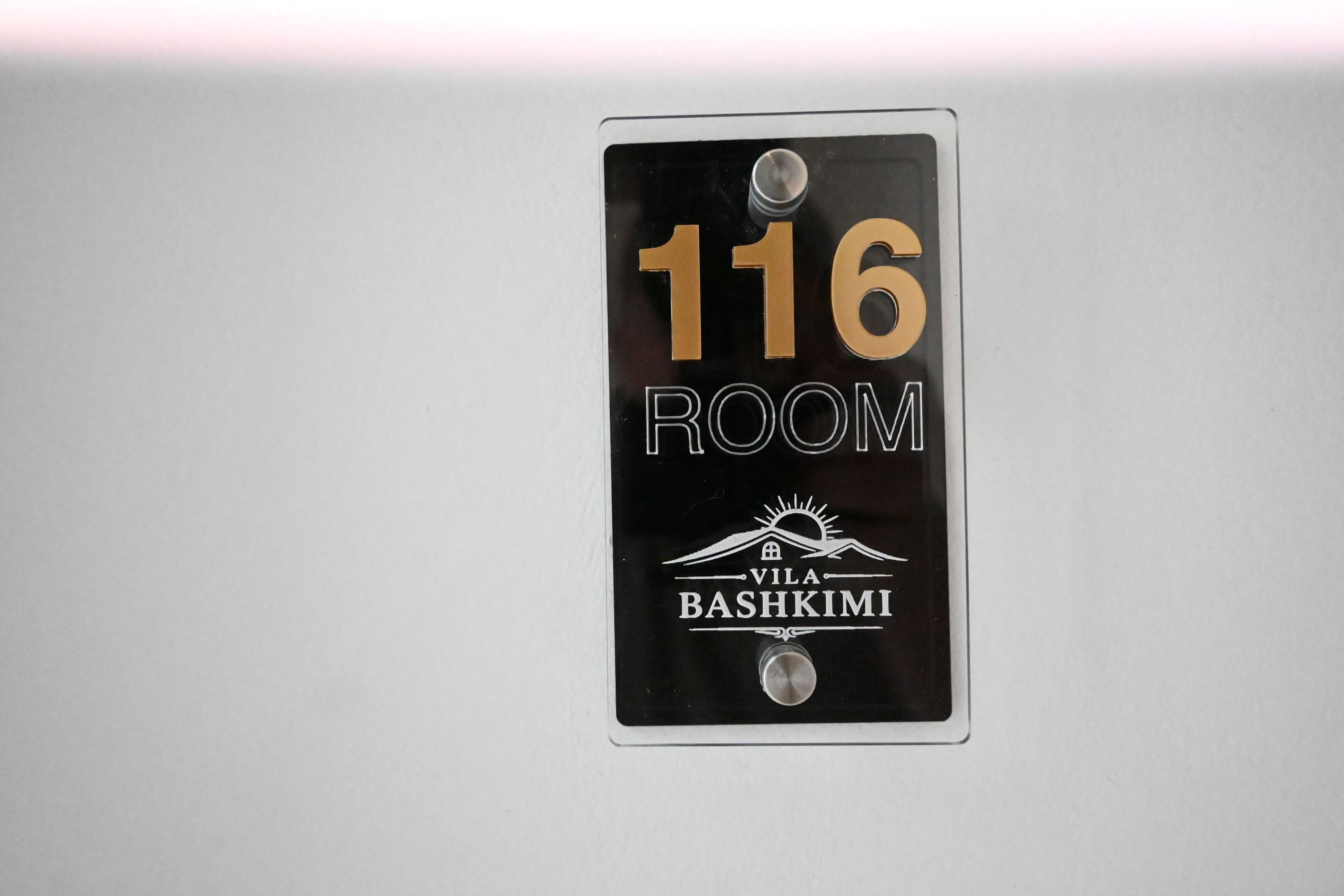 A room number sign for room 116 at Vila Bashkimi.