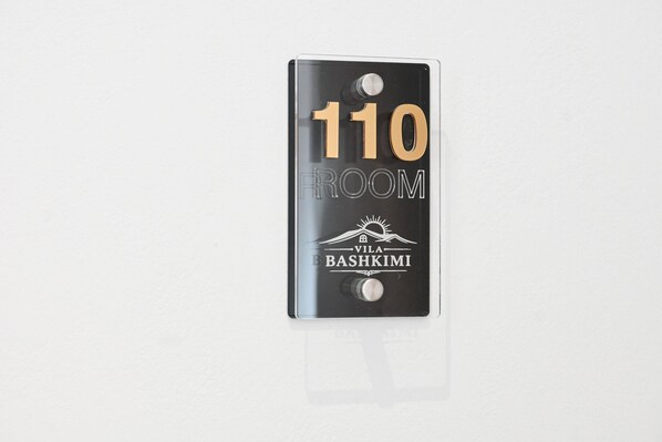 A room number sign for room 110 with the name "Bashkimi" and a mountain icon. - Vila Bashkim (Ksamil)