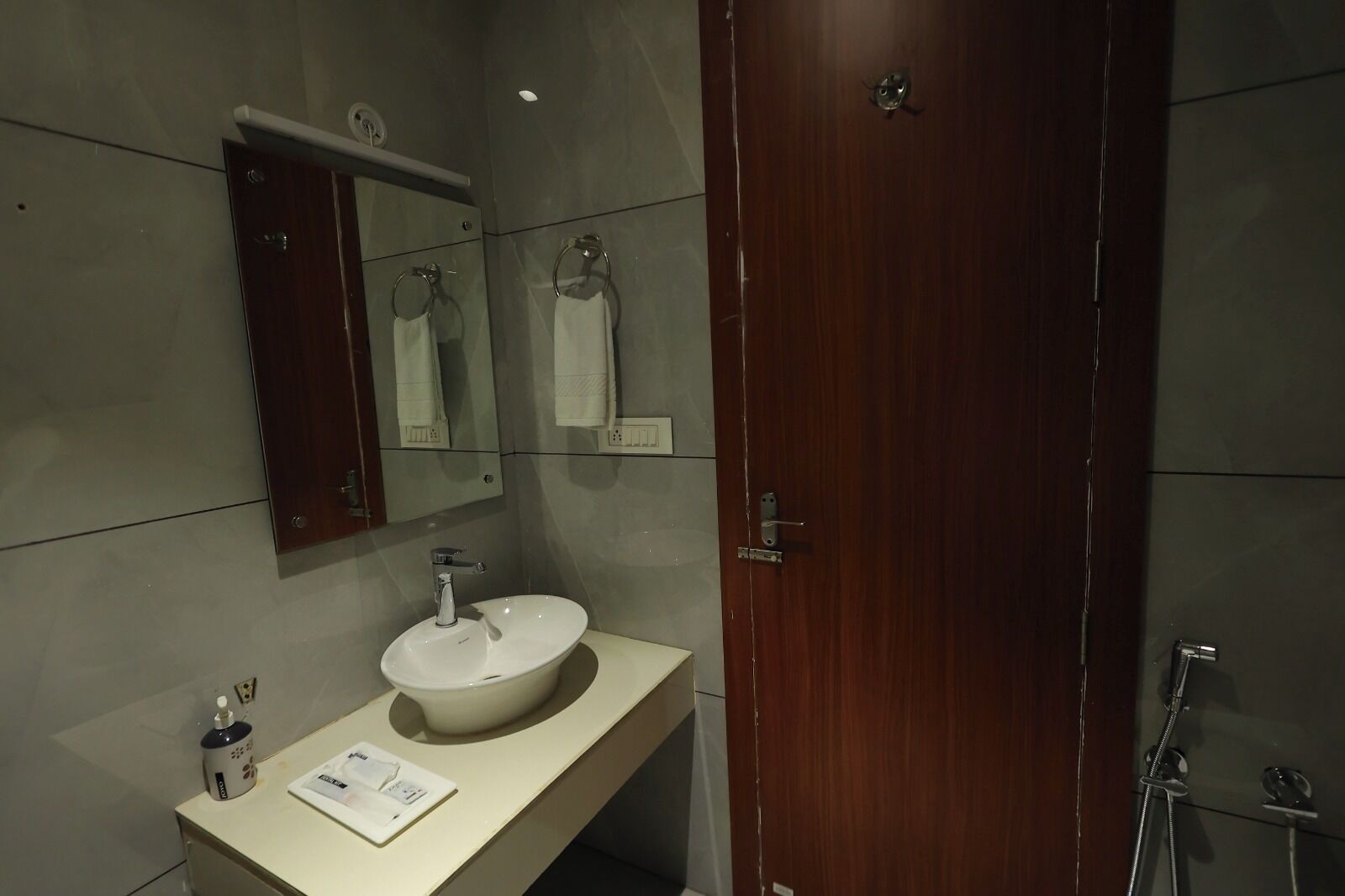 A modern bathroom with a large mirror, a sink, and a shower.