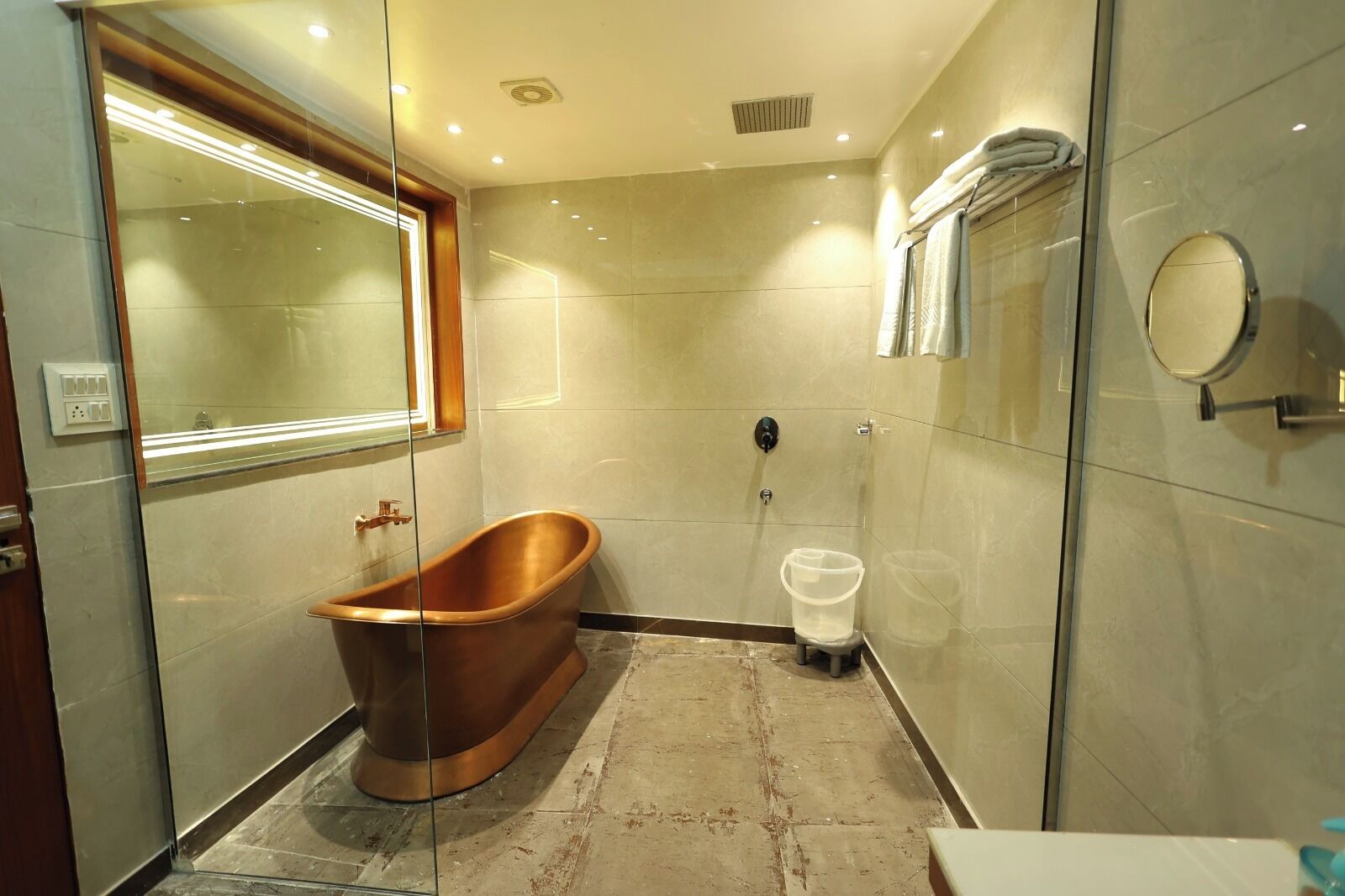 A modern bathroom with a freestanding bathtub, a glass shower enclosure, and a large mirror.