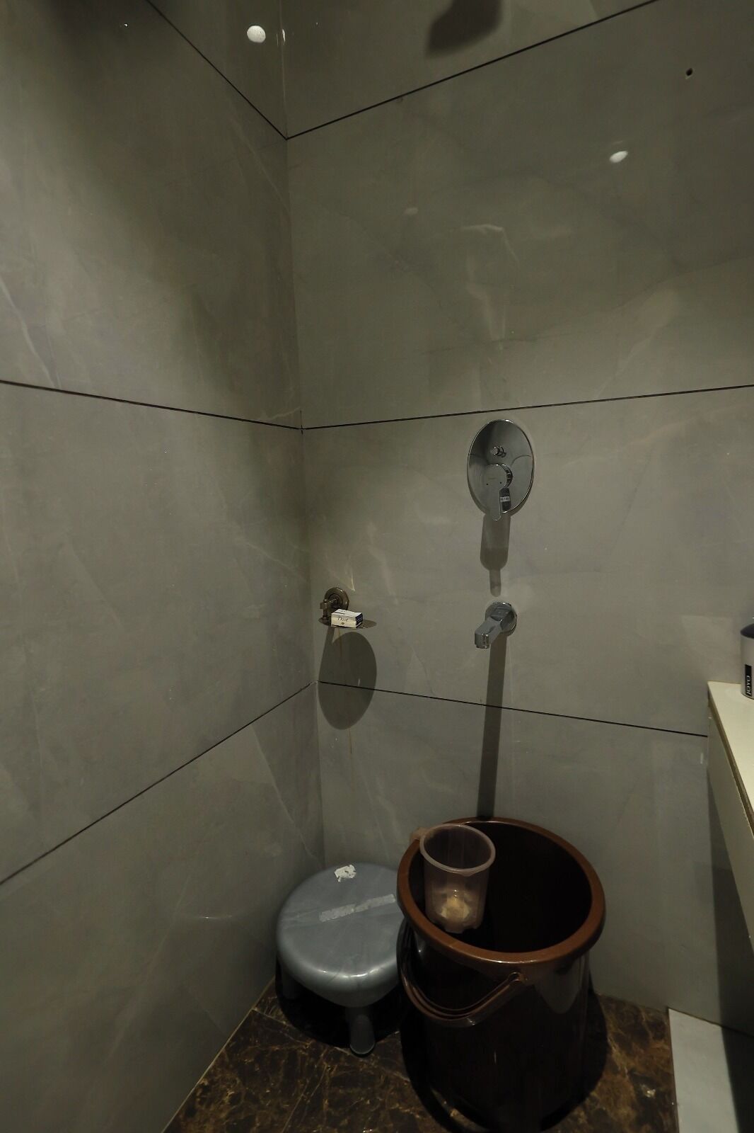 A small, modern bathroom with a toilet, bidet, and a trash can.