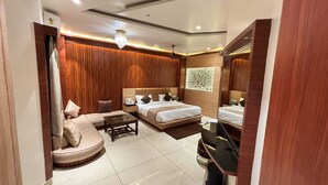 Een moderne hotelkamer met een groot bed, een bank, een tafeltje en een spiegel.