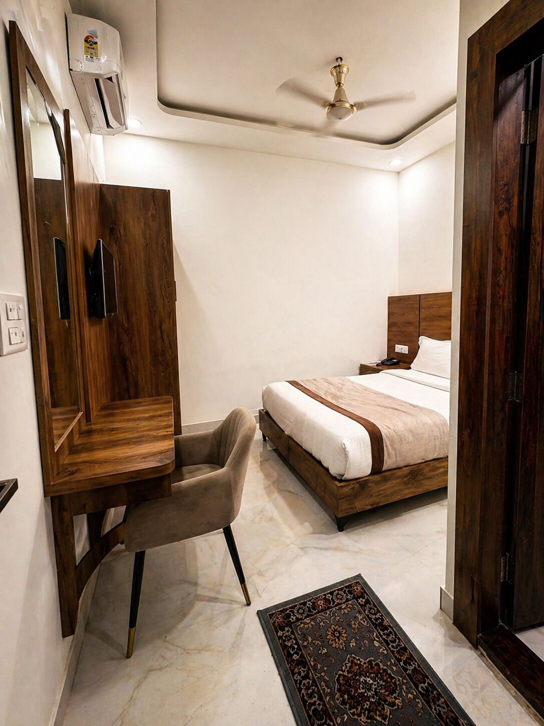 A bedroom with a bed, a chair, a wardrobe, and a ceiling fan.