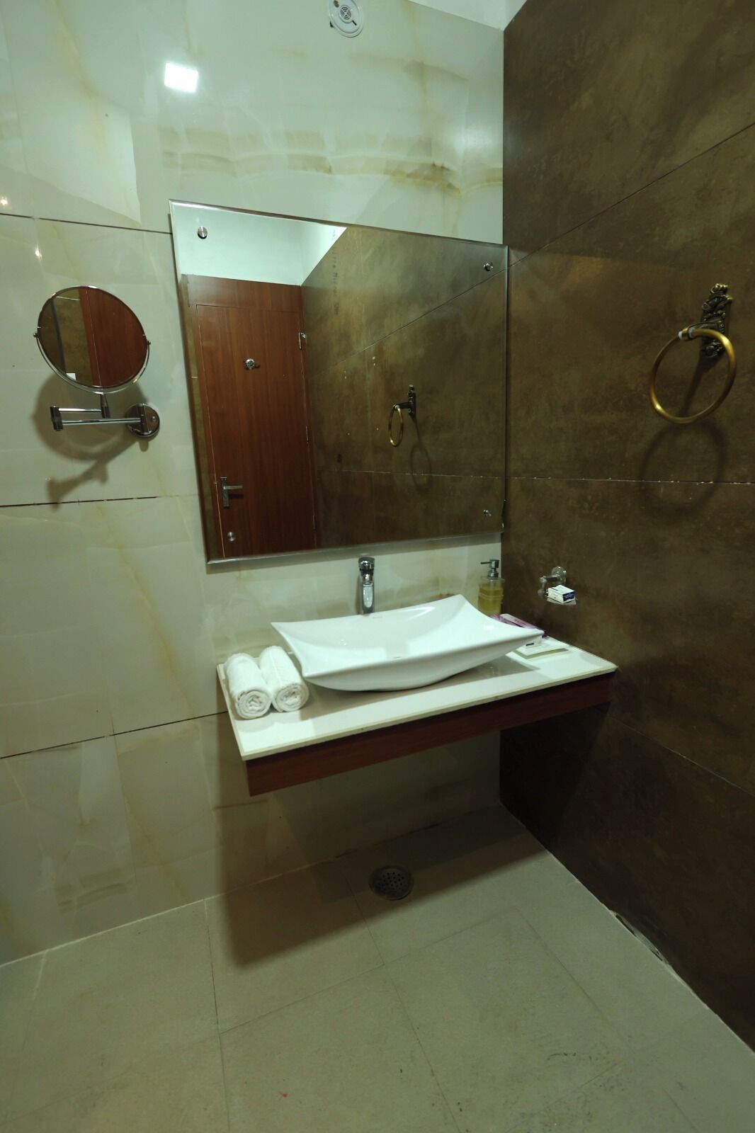 A bathroom with a white sink, a mirror, and a towel rack.