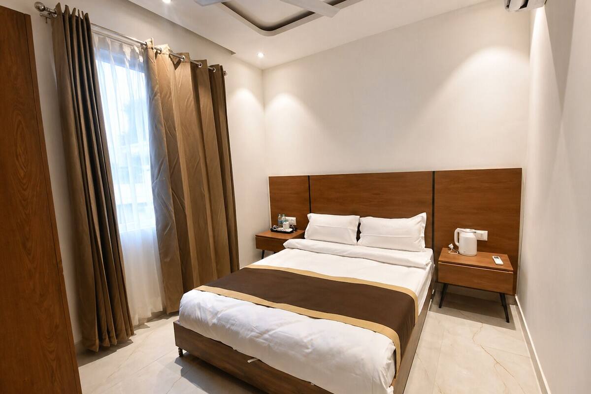 A hotel room with a large bed, wooden headboard, bedside tables, and a ceiling fan.