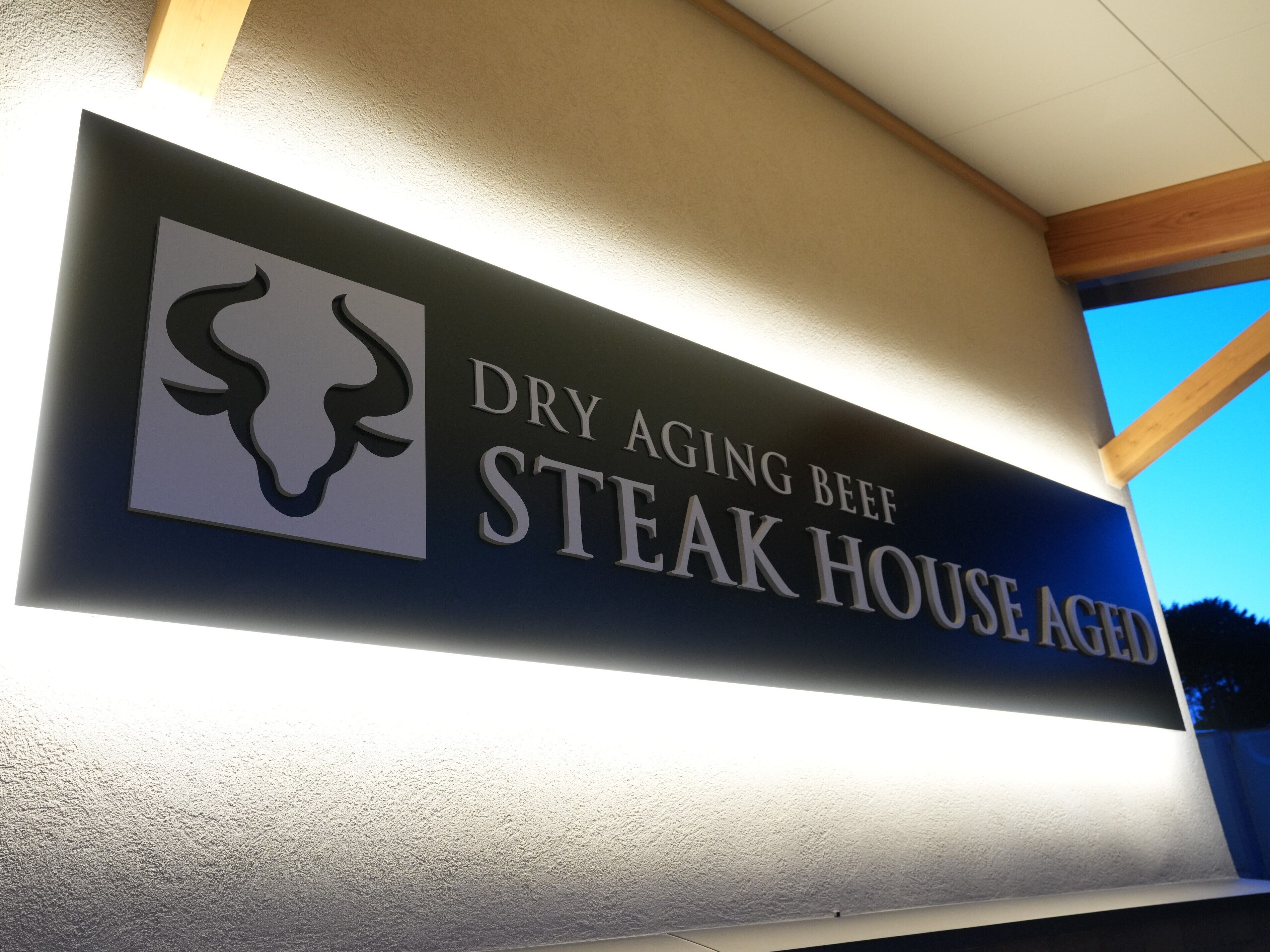 Een bord voor een steakhouse met een logo en naam.