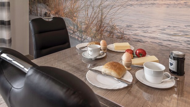Een ontbijttafel met een croissant, eieren en een koffiekop.