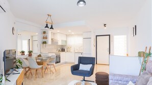 Ein modernes Wohnzimmer mit Essbereich, Küche und einer Couch.