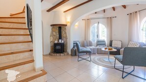 Una sala de estar con chimenea de piedra, un conjunto de sofás y una mesa de comedor.