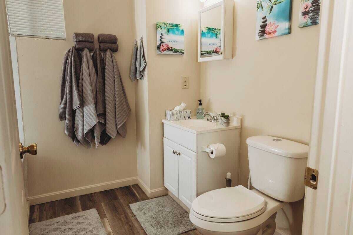 Une petite salle de bain avec des toilettes, un lavabo et un porte-serviettes.