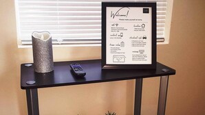 A framed welcome sign with house rules and contact information on a black table. - Cozy Retreat Near Fort Meade | Fire Pit (Severn)