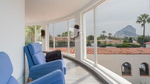 Ein modernes Zimmer mit großen Fenstern, einer gewölbten Decke und Blick auf Berg und Stadtpanorama.