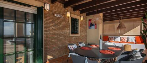 A dining area with a brick wall, a large window, and a table with chairs.