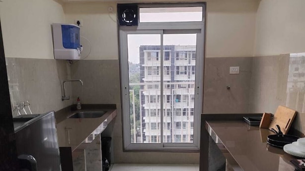 Eine moderne Küche mit Backofen, Spüle und Fenster mit Blick auf ein Wohngebäude.