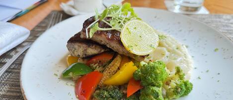 A plate of food with a variety of vegetables and a slice of lemon on top.