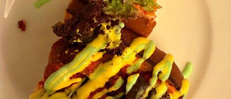 A plate of nachos topped with cheese, lettuce, and a yellow sauce.