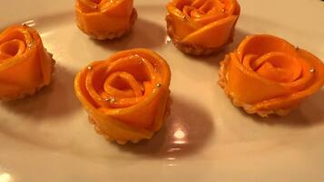 Un plato blanco con seis pequeñas pastas con forma de rosa.
