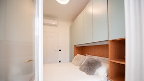 A bedroom with a bed, a wardrobe, and a door. - La Casa del Lago in Manerba del Garda (Manerba del Garda)
