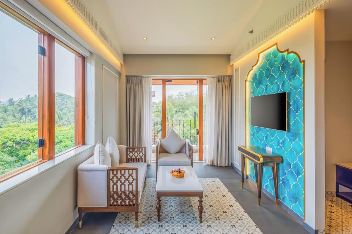 A spacious room with a sofa, a coffee table, and a TV mounted on a wall with a decorative blue pattern.
