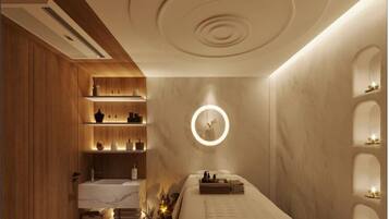 A spa room with a wooden floor, a massage table, and a ceiling with circular light fixtures.
