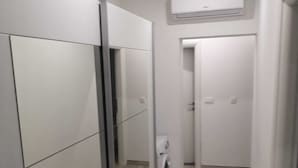 A narrow hallway with a washing machine, a door, and an air conditioning unit. - Apartman Sea Lake Magic 1 (Vinodol)