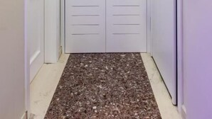 A hallway with a white door and a white wardrobe.
