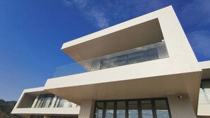 Un edificio moderno a due piani con ampie finestre e un balcone.