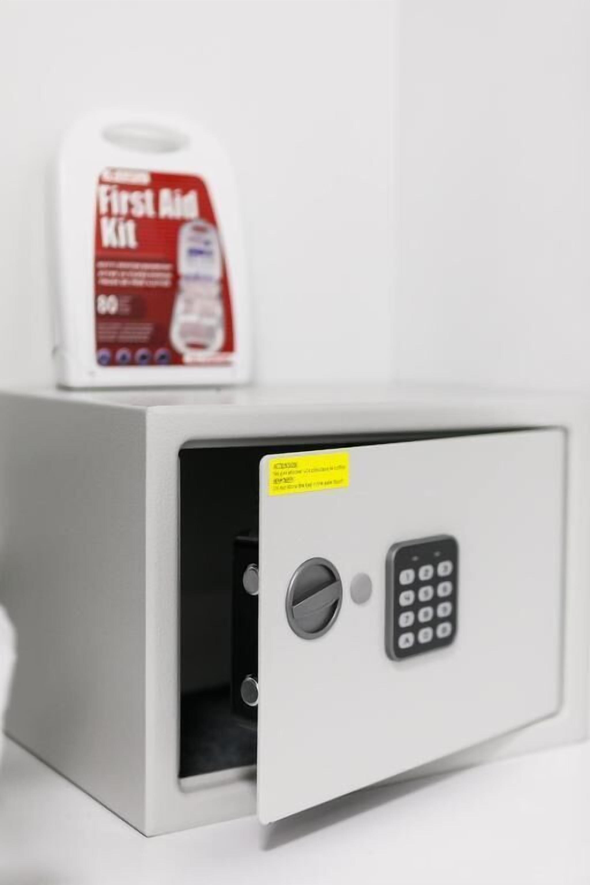 A white safe with a keypad and a small window.