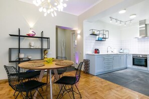 Enjoy meals in the kitchen and dining area, featuring a stove, oven, and round table with black chairs.