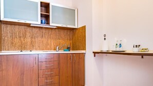 Une cuisine compacte avec des meubles en bois, un four à micro-ondes encastré et un petit plan de travail.