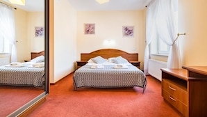 Une chambre d’hôtel avec un lit, une table de chevet et un miroir.