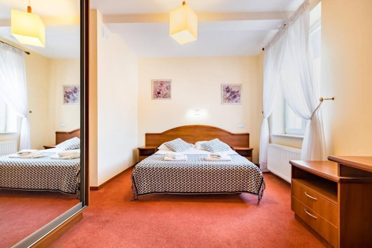 Une chambre d’hôtel avec un lit, une table de chevet et un miroir.