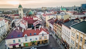 Une vue d’une rue pittoresque d’une ville historique, avec son architecture traditionnelle, notamment une église imposante dotée d’un dôme vert et d’un clocher.