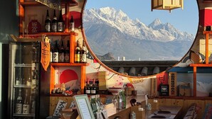 A bar with a view of snow-capped mountains through a circular window. -  Lijiang Snow Mountain Bengu Hotel (Shuhe Ancient Town Branch) (Lijiang)