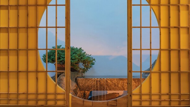 A circular window with a grid pattern, through which a tree and a rocky landscape are visible. -  Lijiang Snow Mountain Bengu Hotel (Shuhe Ancient Town Branch) (Lijiang)